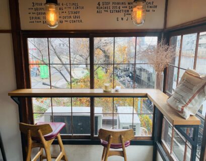 brown wooden table near glass window