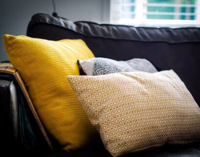 three assorted-color throw pillows on black sofa