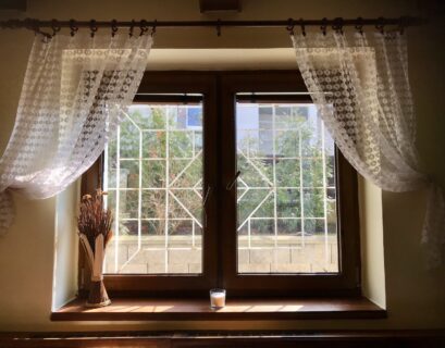 white floral window curtain on white wooden framed glass window