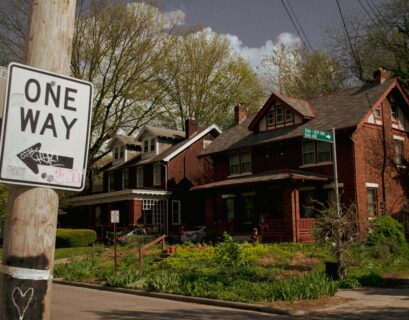 white and black street sign near brown house during daytime
