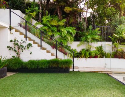 a white house with a green lawn and stairs